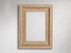 an empty wooden frame hanging on the wall with a white painted wall in the background