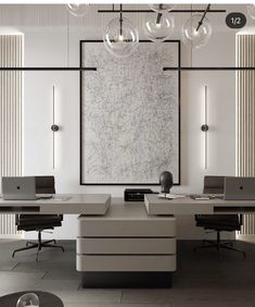 an office with two desks and three laptops on the same desk in front of a large painting