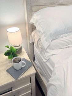 there is a cup of coffee on the nightstand next to the bed