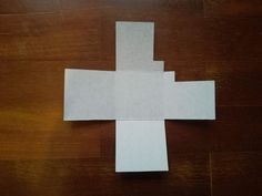 a cross made out of paper sitting on top of a wooden table