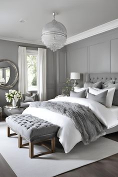 a bedroom with gray walls and white bedding, an upholstered bench in the middle