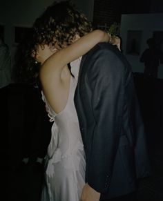 a man in a suit and tie hugging a woman on the dance floor at a wedding