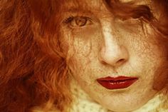 a woman with freckled hair and red lipstick