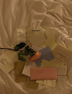 a rose is sitting on top of some papers and post it notes that have been placed together