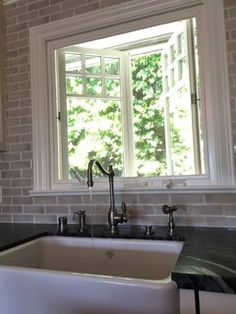 a white sink sitting under a window in a kitchen