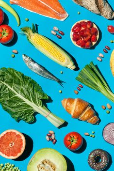 an assortment of fruits and vegetables on a blue background by julia radda for stocksy