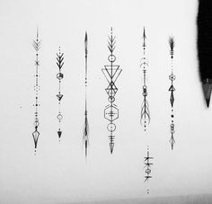 an assortment of arrows and other tattoos on a white sheet with black ink in the middle