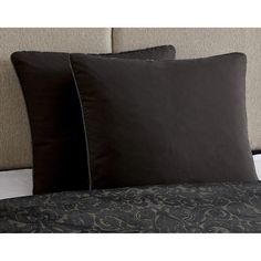 two black pillows sitting on top of a bed