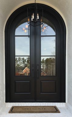 a black double door with two sidelights and a rug on the floor in front of it