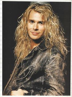 a man with long blonde hair wearing a leather jacket