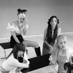 four young women sitting on chairs in a room with one woman holding her hair up