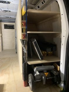 the inside of a van with shelves and tools on it's sides, including wheels