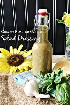 a bottle filled with salad dressing sitting on top of a table next to some flowers