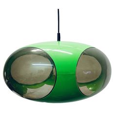 a green hanging light with two round mirrors on the front and back of it's sides