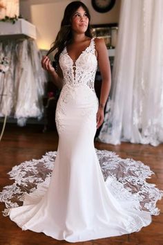 a woman in a white wedding dress posing for the camera with her hands on her hips