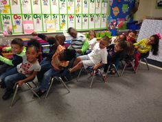 a group of children sitting in chairs with their backs to each other