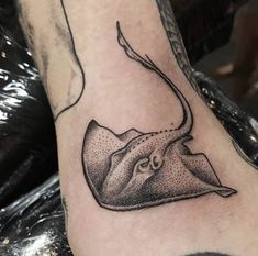 a manta ray tattoo on the left leg