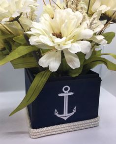 white flowers are in a blue box with an anchor