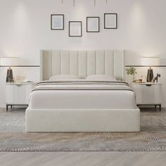 a white bed sitting on top of a wooden floor next to two nightstands and lamps