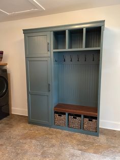 a laundry room with a washer, dryer and cabinets on the wall next to it