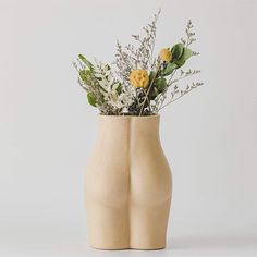 a vase with flowers in it sitting on a table next to a white wall or floor