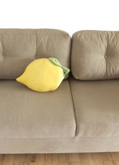 a yellow pillow sitting on top of a gray couch