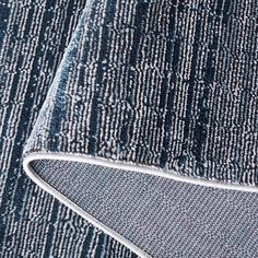 an area rug with blue and white lines on it, including the corner of a piece of fabric that has been stitched together