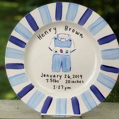 a blue and white plate with an image of a baby's overalls on it