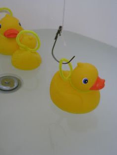 two rubber ducks sitting on top of a bath tub next to a shower faucet