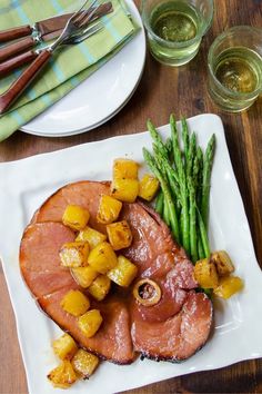 ham with asparagus and pineapples on a white plate