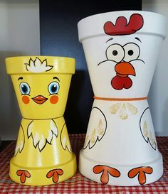 two painted pots sitting on top of a red and white checkerboard tablecloth