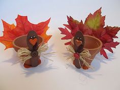 two potted plants with fake turkeys and fall leaves in the shape of pumpkins