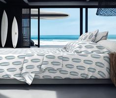 a bedroom with surfboards on the wall next to it and a bed in front of an open window