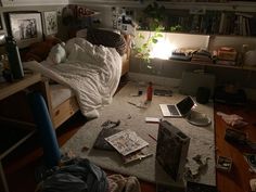 an unmade bed sitting on top of a wooden floor next to a laptop computer