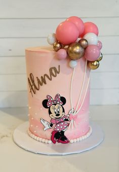 a minnie mouse birthday cake with balloons on top