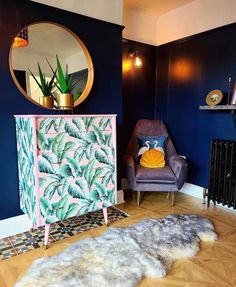 a living room with blue walls and an animal rug in front of a pink cabinet