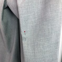 a person wearing a gray shirt with a red pin on it