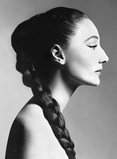 a black and white photo of a woman with braids in her hair looking to the side