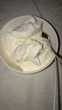 a white plate topped with ice cream next to a spoon