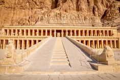 an ancient building in the desert with steps leading up to it and mountains behind it