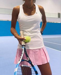 a woman holding a tennis racket and ball