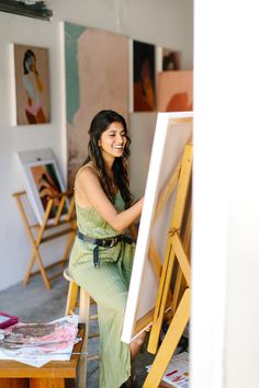 a woman sitting in front of an easel with the words personal brand photoshoot for bay area artist