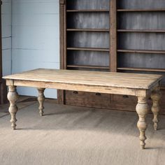 an old wooden table sitting in front of a bookcase