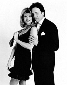 black and white photograph of man and woman in formal wear posing for the camera with their arms around each other