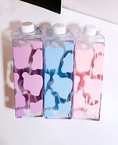 three bottles with hearts painted on them sitting next to each other