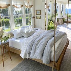 a bedroom with a canopy bed and two windows overlooking the ocean is featured in this postcard