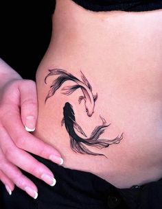 a woman's stomach with a fish tattoo on it