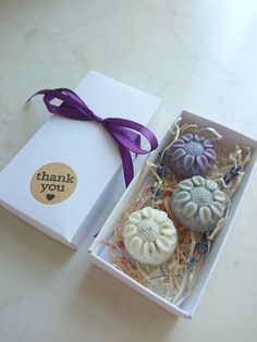 three soaps in a gift box with a purple ribbon and thank you sticker