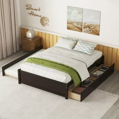 a bed sitting on top of a wooden floor next to two pictures hanging above it