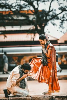 a man kneeling down next to a woman